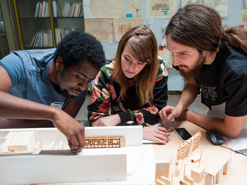 Three students work together on a City Center project at desk