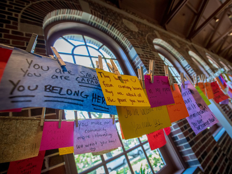 Handwritten messages of support for the community are strung along a room